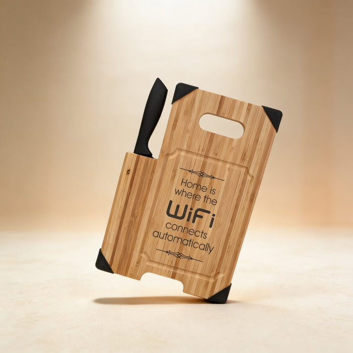 Custom engraved bamboo cutting board laid flat with chef's knife, laser engraved monogram visible
