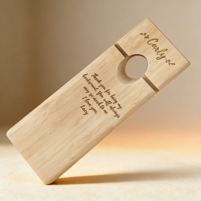 Laser engraved bamboo wine balancer with monogram, shown as a wedding table display piece