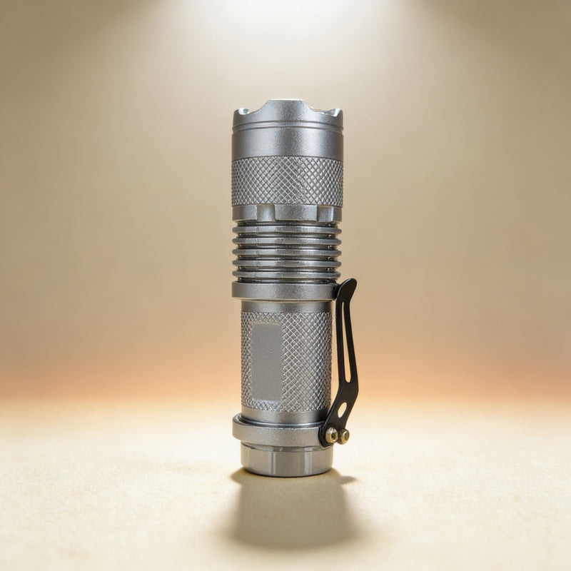 Custom engraved silver focus flashlight showing adjustable magnifying lens and window breaker bezel