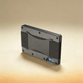 Personalized aluminum card holder engraved with monogram, shown beside cards and cash